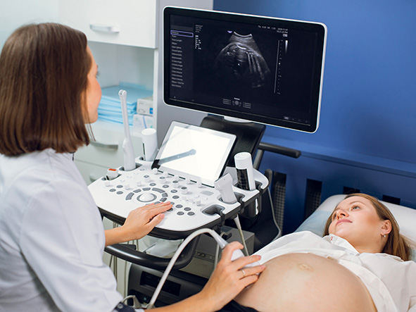 sage femme pratiquant une échographie de suivi obstétrique